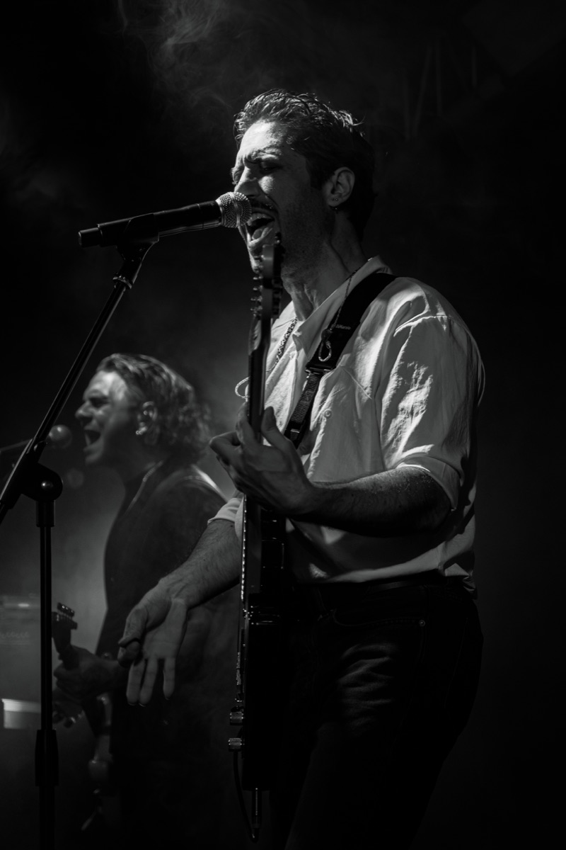Caner Karamukluoğlu sahnede vokal ve gitar performansı sırasında