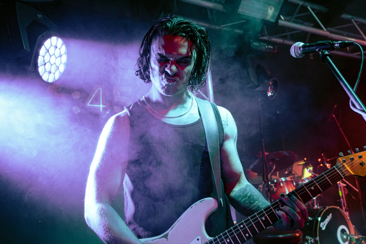 TNK gitaristi renkli sahne ışıkları altında